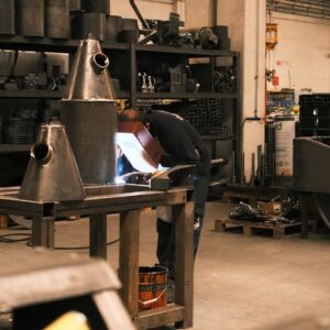 Um Homem Trabalhando Em Um Pedaco De Papel Em Uma Fabrica pun3UkaC5VY