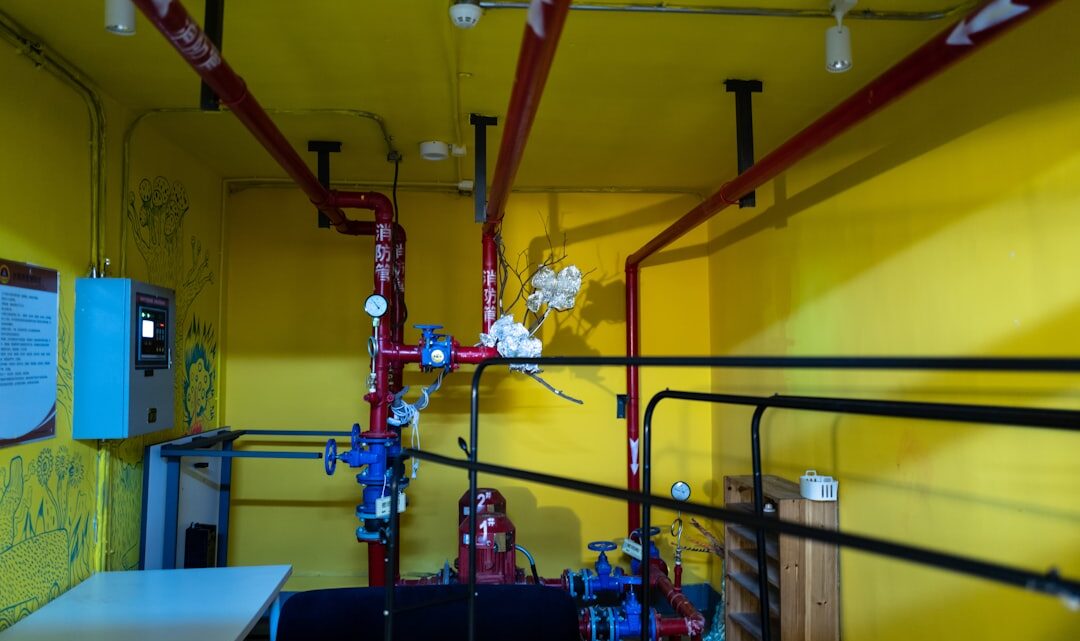 Uma Sala Com Paredes Amarelas E Tubos Vermelhos C80fSAOkEqE