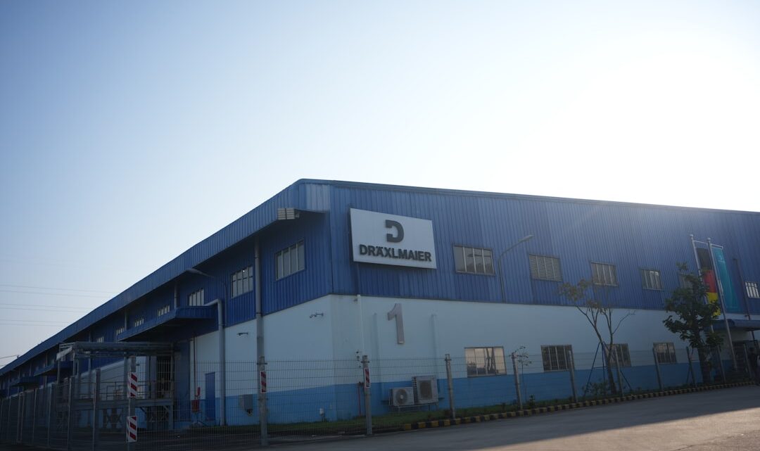 Predio Industrial Azul Com Logotipo Da Empresa Sob Ceu Limpo fb2leZe8xfQ
