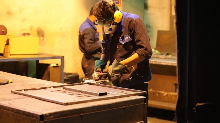 Homem Na Camisa Vermelha De Manga Comprida E Capacete Amarelo Segurando Caixa De Madeira Marrom USL4x8YMbs4