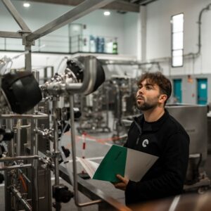 Um Homem Inspeciona Maquinas Em Uma Fabrica VFrbWve7eAs