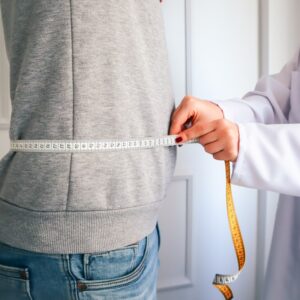 Uma Mulher Medindo Sua Cintura Com Uma Fita Metrica oThoRP1zGzE