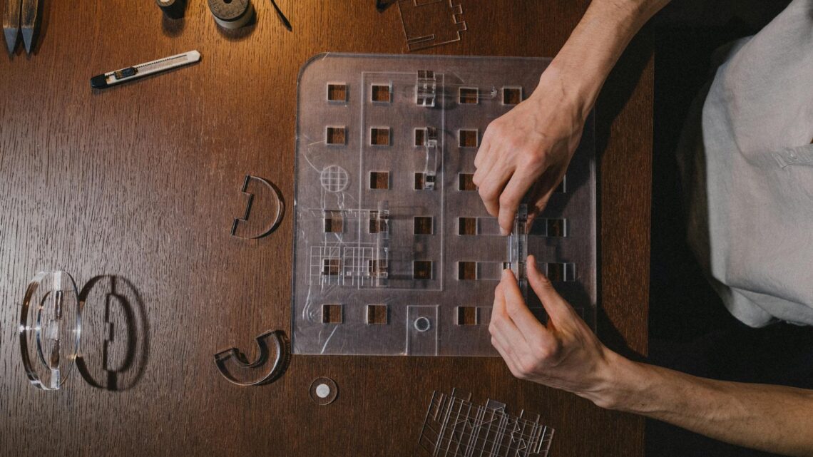 Architect creating a model on a wooden desk, showcasing creativity and design skills.
