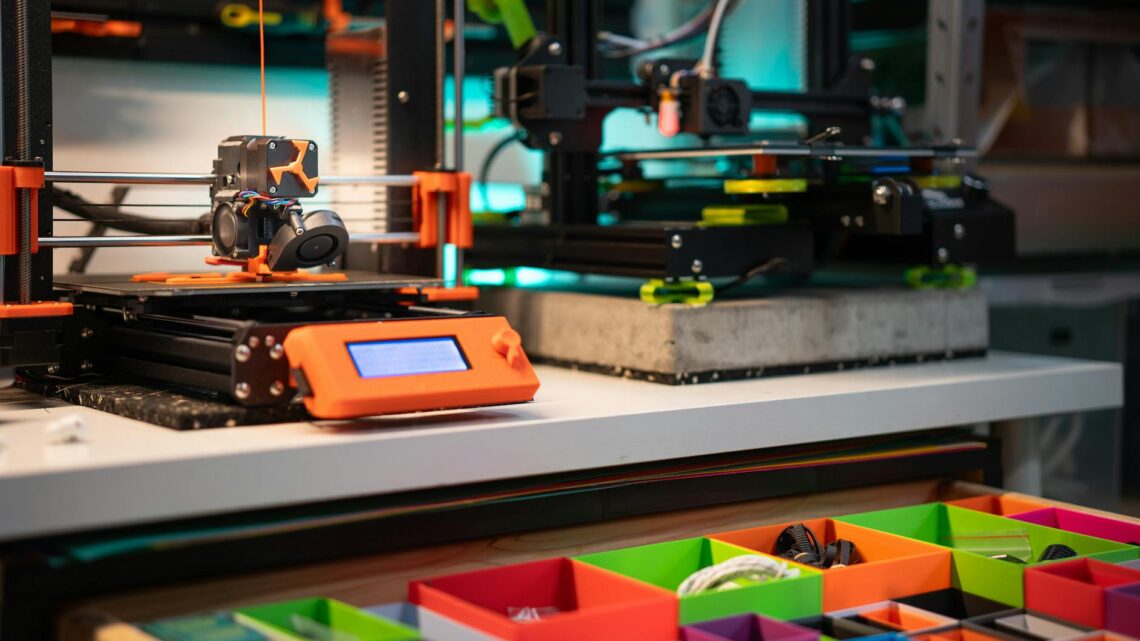 Vibrant 3D printing station showcasing modern equipment and organized storage boxes.