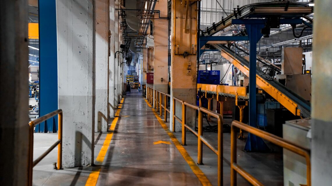 Wide view of a modern factory interior showcasing industrial machinery and conveyor systems.
