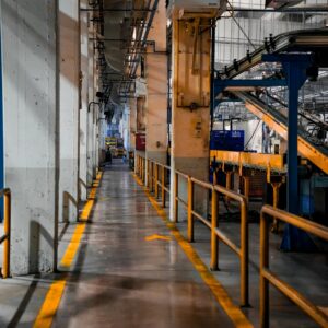 Inside view of an industrial factory featuring conveyor belts and empty walkways.