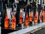 Glass bottles on a production line in a modern glass factory, showcasing industrial automation.