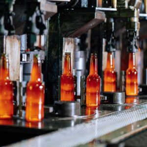 Glass bottles on a production line in a modern glass factory, showcasing industrial automation.