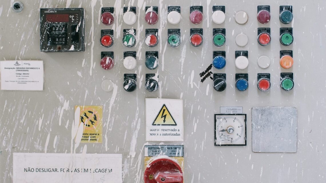 Close-up of an industrial control panel with colorful warning buttons and switches.
