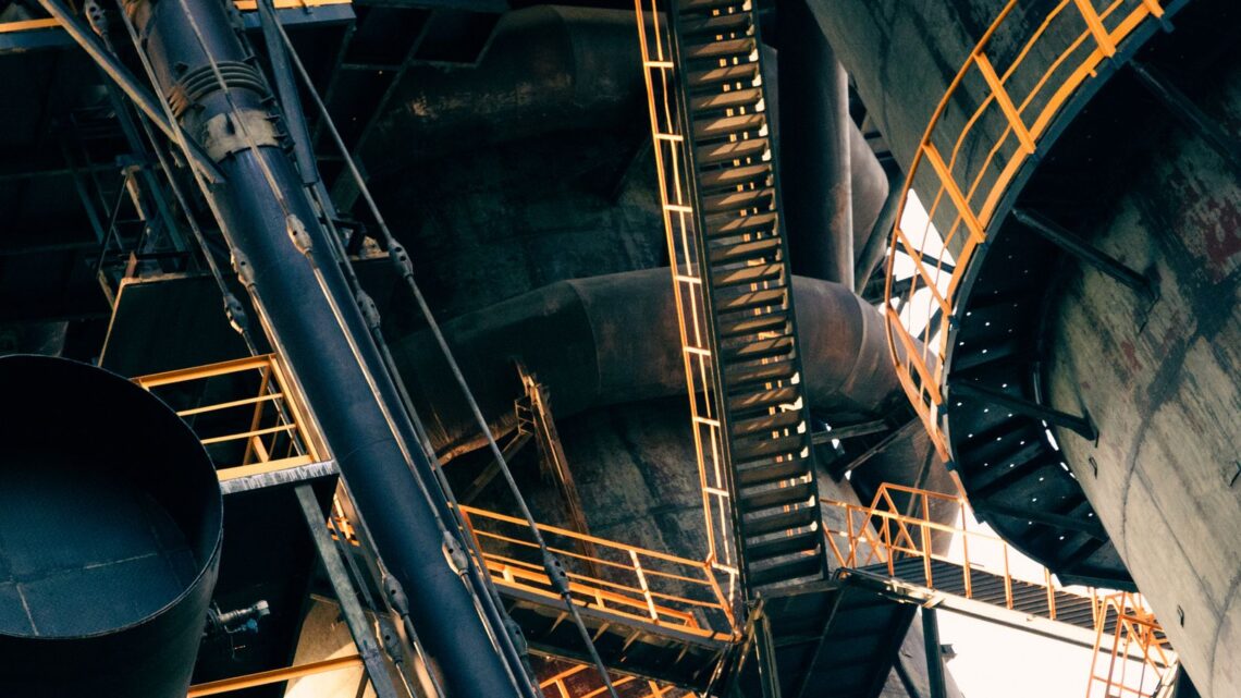 Intricate view of metal stairs and structures in a large industrial facility.