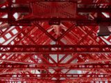 Detailed view of a red steel framework showing geometric patterns and industrial design.
