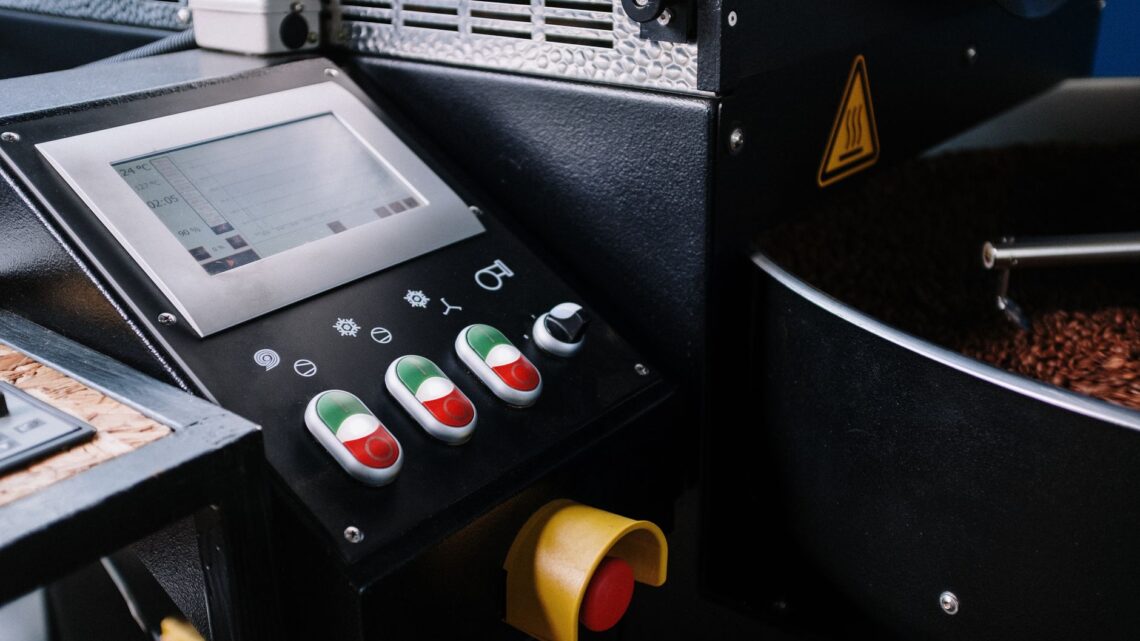 Detailed view of a coffee roaster control panel showing buttons and beans.