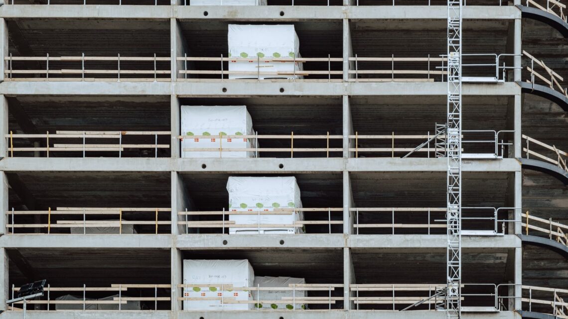 Close-up of a multi-storey building under construction, showcasing steel and concrete structure.