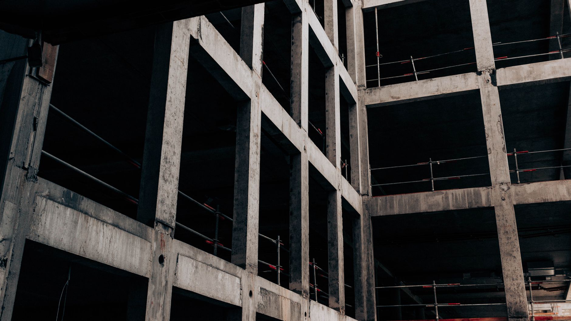 Low angle of unfinished abandoned building with concrete walls at construction site in industrial area