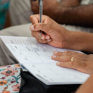 A woman writing in a calendar planner, highlighting organization and time management.
