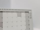 Spiral-bound calendar showing May with focus on weekdays in Portuguese.