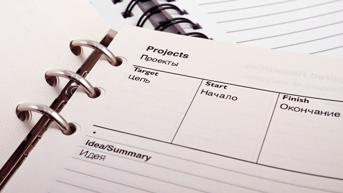 Open planner displaying project schedule with Russian-English text, ideal for office or educational content.
