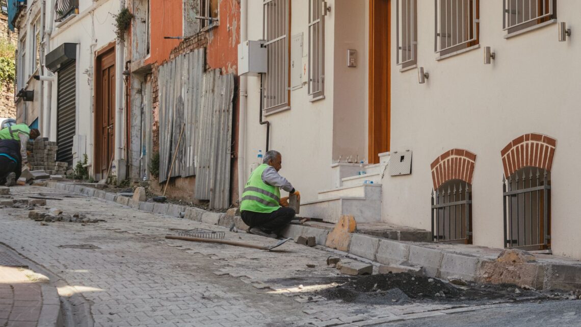 Construction workers repairing an urban street, showcasing teamwork and hard work.