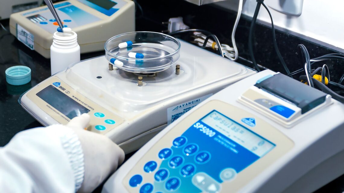 Close-up of laboratory equipment with capsules, capturing pharmaceutical analysis.