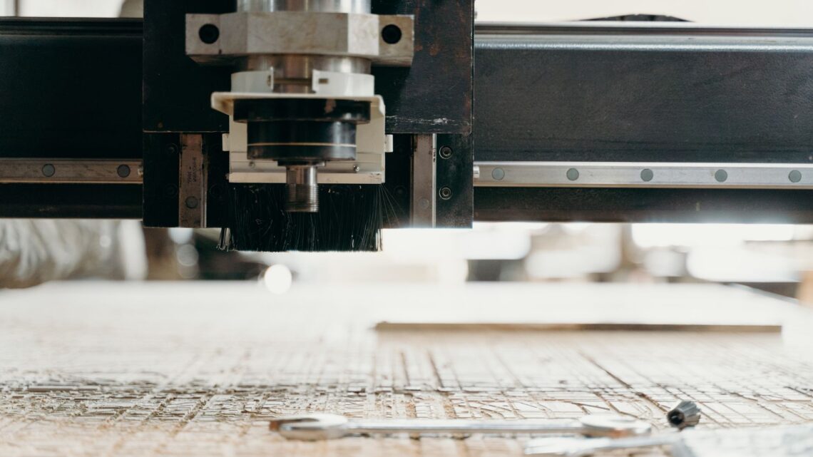 Close-up of a CNC machine carving a wooden surface indoors, showcasing precision equipment.