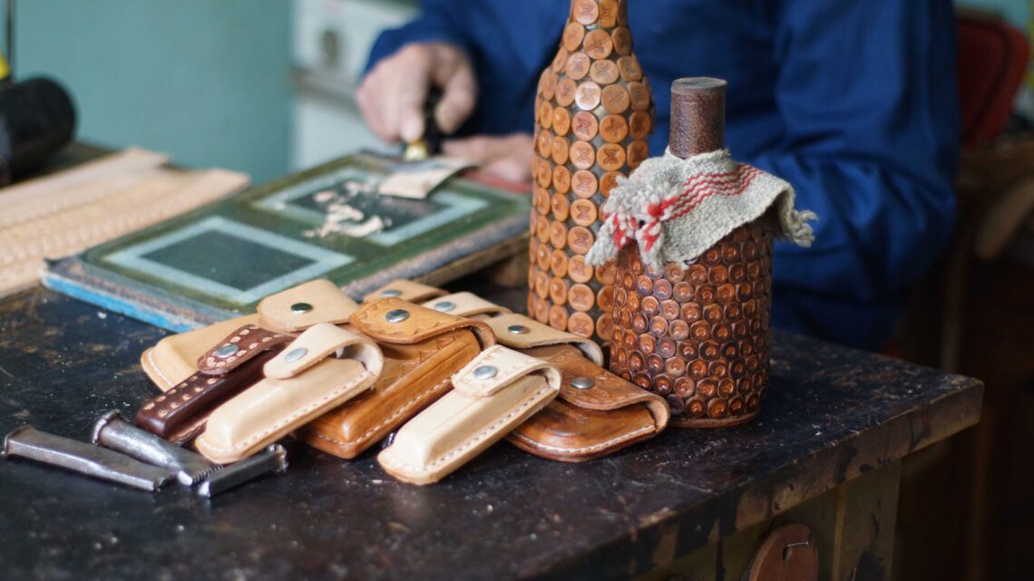 Close-up of artisan leathercrafting with handmade leather products in a traditional workshop.