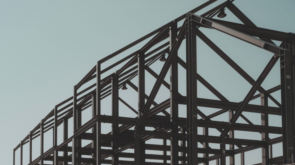 Modern steel framework structure under clear sky, showcasing architectural design.